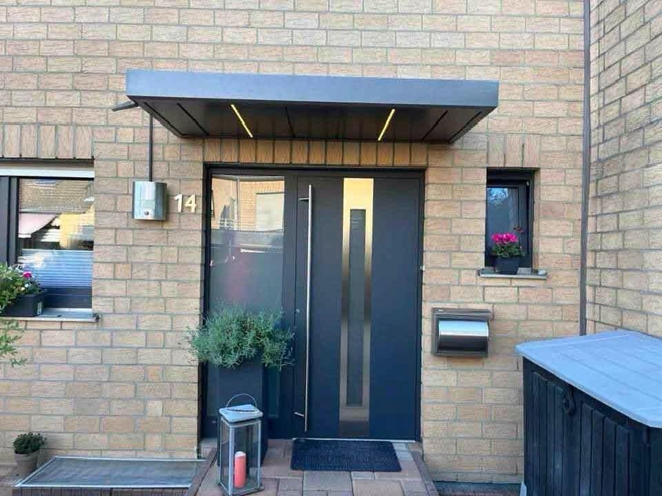 Dunkle Haustür mit geradlinigem Vordach