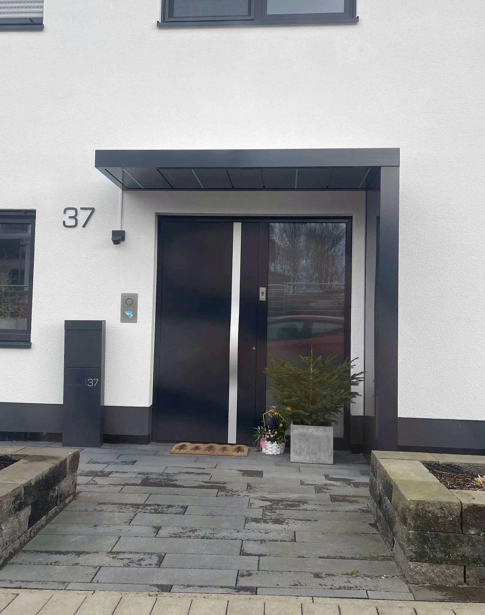 Dunkle Haustür mit modernem Vordach