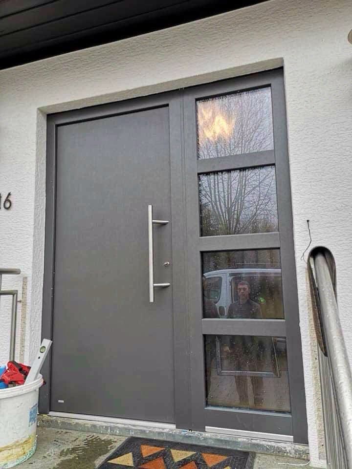 Graue Haustür mit seitlichen Glaselementen